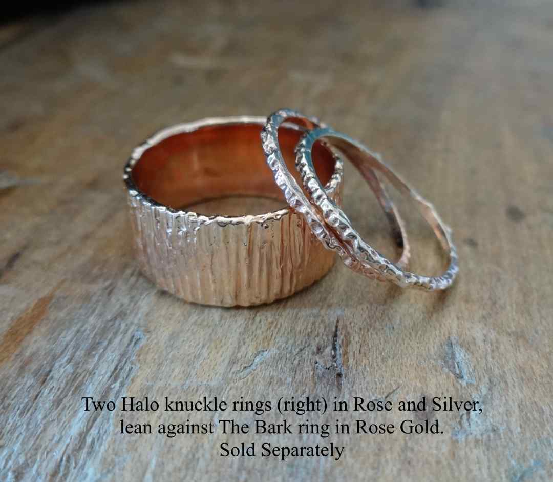 Halo ring stackers resting on Bark solid in Rose and Gold